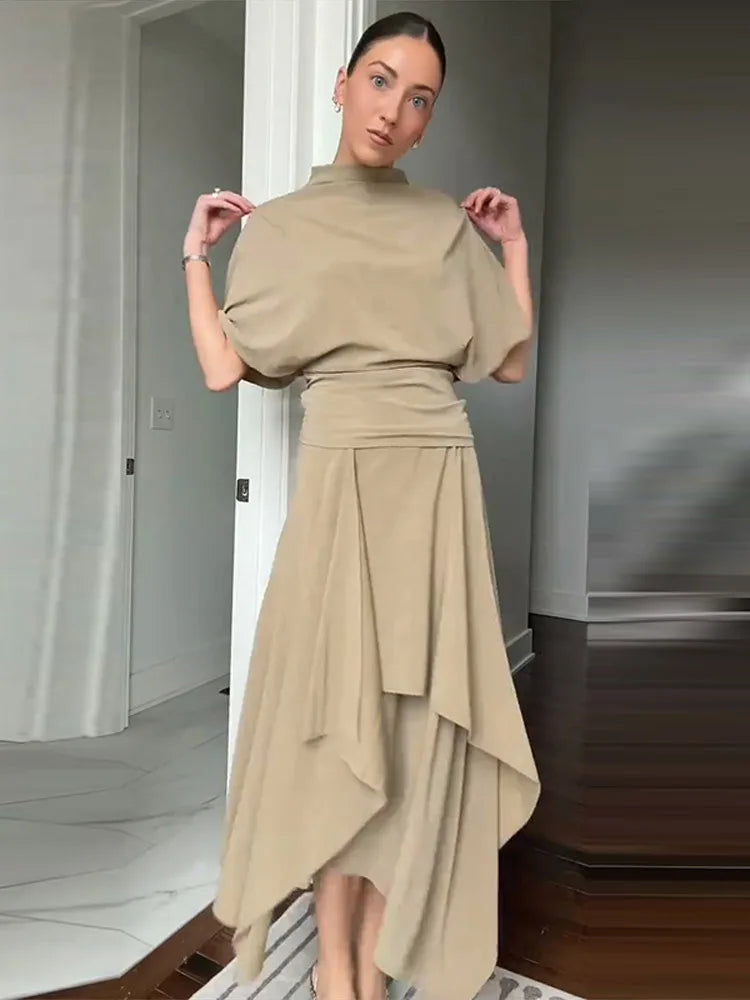 Completo da donna a due pezzi tinta unita con top a collo alto a maniche corte e gonna lunga asimmetrica drappeggiata a trapezio, outfit casual estivo da donna 2026